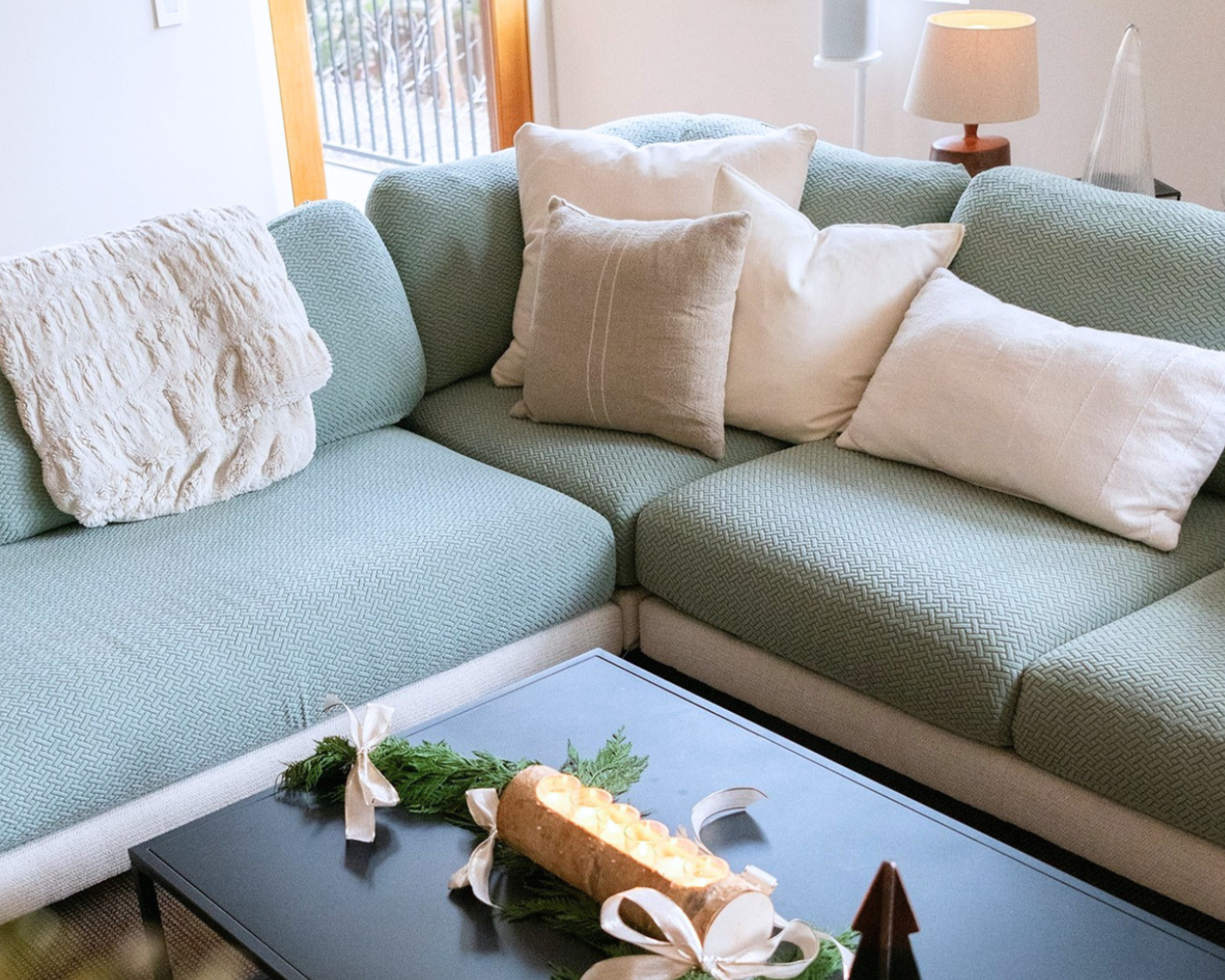 Light blue sectional sofa with decorative pillows in a living room setting.