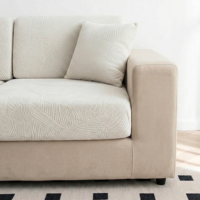 Beige sofa with white textured sofa cover that has leaf jacquard pattern in a minimalistic room