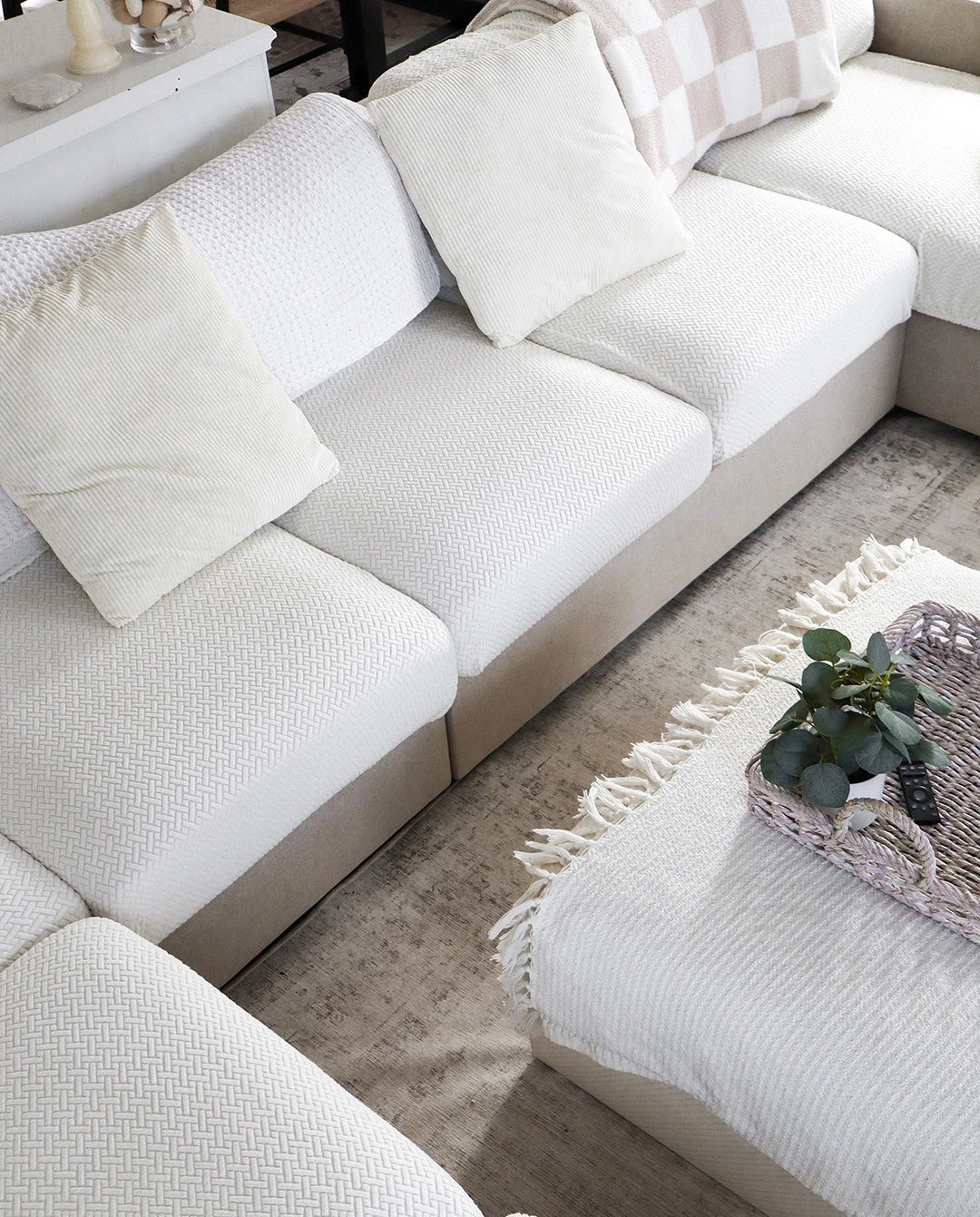 White sectional sofa with cushions in a living room setting