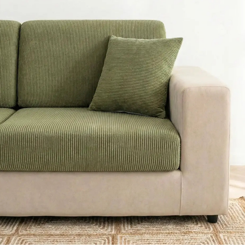 Green corduroy sofa with a matching pillow on a neutral background